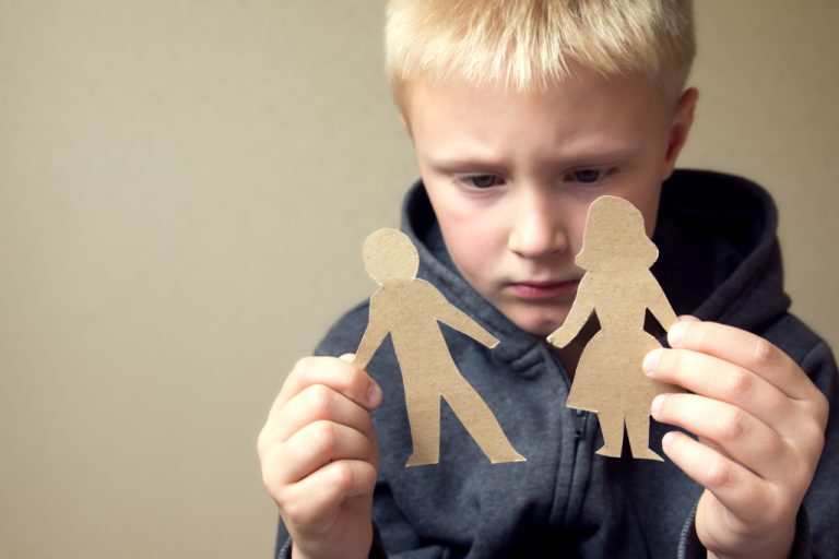 child holding paper figure of parents
