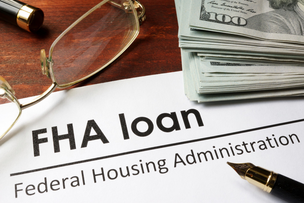 FHA loan document, money, a pen, and glasses