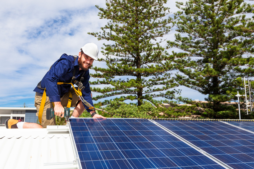 man installing solar panels on the roof