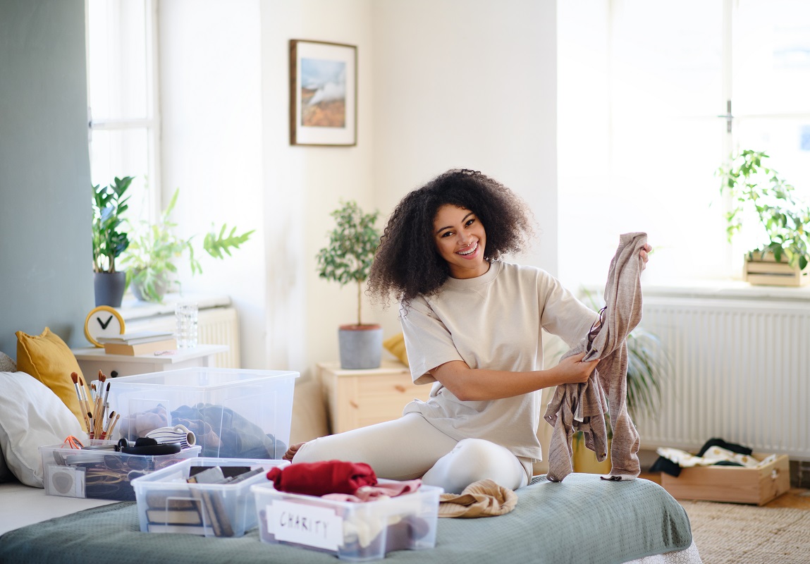 Young woman decluttering her wardrobe cabinet.