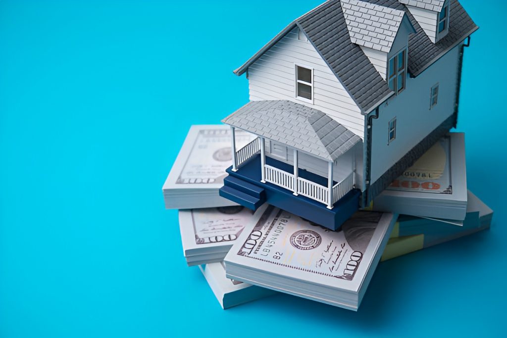stacks of US dollar bills beneath a miniature house